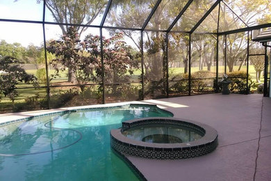 На фото: большой бассейн на заднем дворе в классическом стиле с покрытием из бетонных плит с