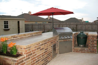 Imagen de patio clásico de tamaño medio sin cubierta en patio trasero con cocina exterior y losas de hormigón