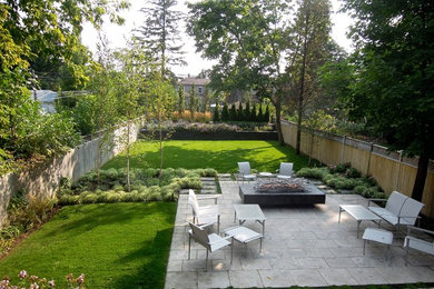 Ejemplo de patio clásico sin cubierta en patio trasero con brasero y adoquines de piedra natural