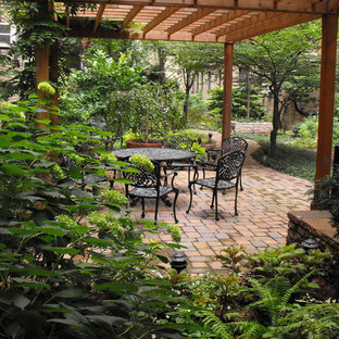 Foto di un grande patio o portico vittoriano dietro casa con una pergola e pavimentazioni in mattoni