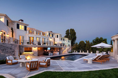 ロサンゼルスにあるラグジュアリーな巨大なトラディショナルスタイルのおしゃれな裏庭のテラス (ファイヤーピット、タイル敷き) の写真