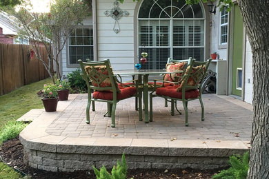 Mid-sized elegant backyard stone patio container garden photo in Dallas with no cover
