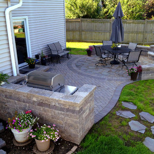 Aménagement d'une terrasse arrière classique de taille moyenne avec un foyer extérieur, des pavés en brique et aucune couverture.