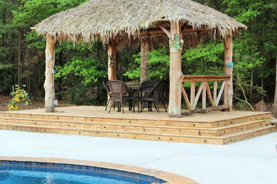 Example of a mid-sized island style backyard patio design in Houston with a gazebo and decking