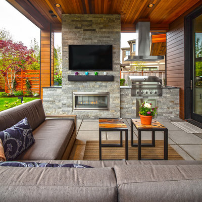 Trendy backyard concrete paver patio photo in Seattle with a roof extension