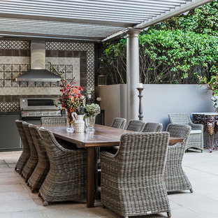 Esempio di un grande patio o portico bohémian dietro casa con pavimentazioni in pietra naturale e una pergola