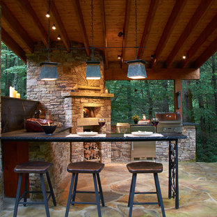 Ispirazione per un patio o portico stile rurale di medie dimensioni e dietro casa con pavimentazioni in pietra naturale e un gazebo o capanno