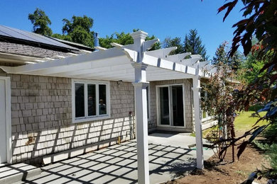 This is an example of a medium sized traditional back patio in Seattle with concrete slabs and a pergola.