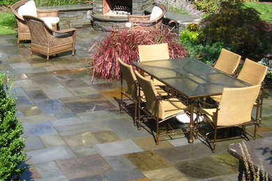 Large elegant backyard tile patio photo in New York with no cover and a fire pit