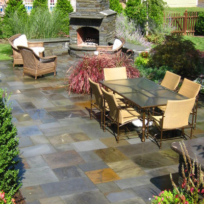 Large elegant backyard tile patio photo in New York with no cover and a fire pit