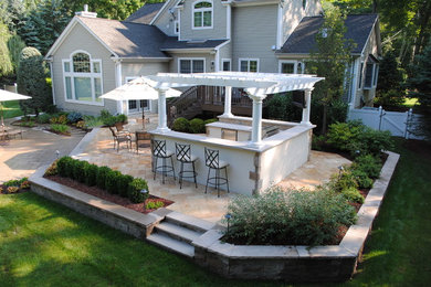 Mid-sized elegant backyard tile patio kitchen photo in New York with a pergola