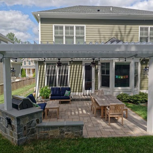 Esempio di un patio o portico american style di medie dimensioni con pavimentazioni in mattoni e una pergola
