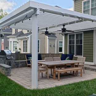 Ispirazione per un patio o portico stile americano di medie dimensioni con pavimentazioni in mattoni e una pergola