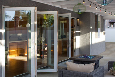 Inspiration for a contemporary backyard concrete patio remodel in Orange County with a roof extension