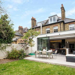 Photo of a medium sized contemporary back patio in London with no cover and tiled flooring.