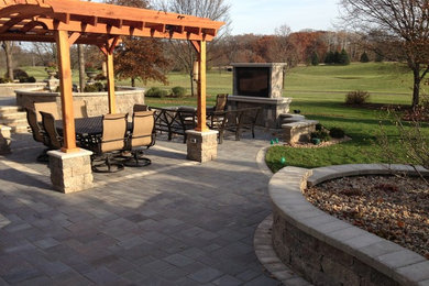 Example of a huge classic backyard concrete paver patio kitchen design in Other with a pergola