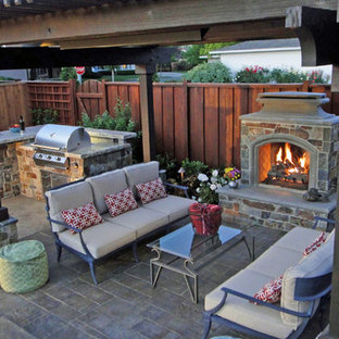 Foto di un patio o portico rustico di medie dimensioni e dietro casa con un focolare, cemento stampato e una pergola