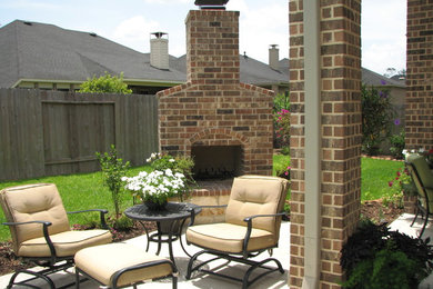 Aménagement d'une terrasse arrière classique de taille moyenne avec un foyer extérieur, une dalle de béton et aucune couverture.