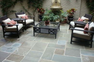 Esempio di un patio o portico tradizionale di medie dimensioni e dietro casa con fontane, pavimentazioni in pietra naturale e nessuna copertura