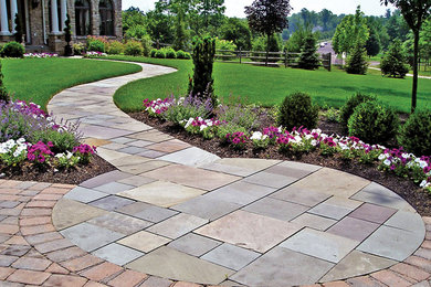 Example of a classic backyard stone patio design in Portland with no cover