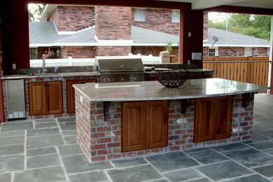 На фото: большой двор на заднем дворе в классическом стиле с летней кухней, покрытием из каменной брусчатки и навесом с