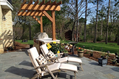 Patio - large traditional backyard patio idea in Other with a pergola
