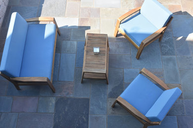 Example of a transitional backyard stone patio design in Other with a pergola