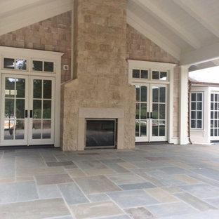 Immagine di un patio o portico american style con pavimentazioni in pietra naturale