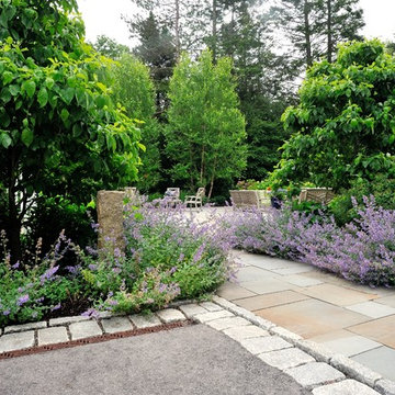 Bluestone walkway, cobblestone borders, plantings and trench drain.