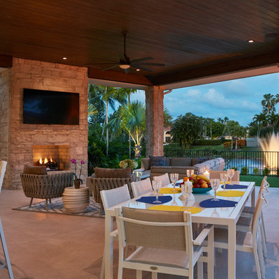 Inspiration for a contemporary backyard patio remodel in Miami with a roof extension and a fireplace