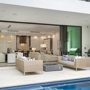 Esempio di un patio o portico minimal con piastrelle e un tetto a sbalzo