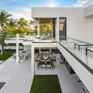 Esempio di un grande patio o portico moderno dietro casa con piastrelle e un tetto a sbalzo