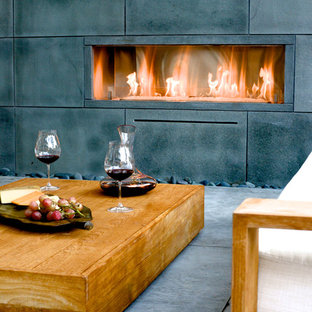 Idee per un patio o portico moderno dietro casa con un focolare e nessuna copertura