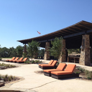 Idee per un ampio patio o portico stile americano dietro casa con graniglia di granito e un tetto a sbalzo