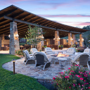 Foto di un ampio patio o portico stile americano dietro casa con pavimentazioni in cemento e un tetto a sbalzo