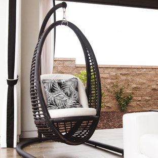 Esempio di un grande patio o portico minimalista dietro casa con piastrelle e un tetto a sbalzo