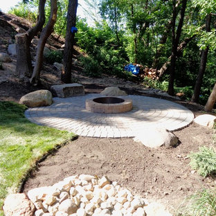 Idee per un grande patio o portico eclettico dietro casa con un focolare e pavimentazioni in cemento