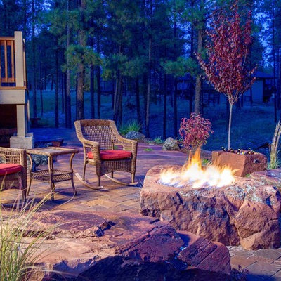 Example of a mid-sized mountain style backyard brick patio design in Denver with a fire pit and no cover
