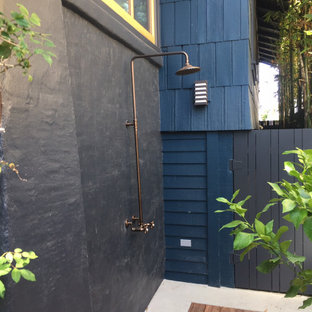 Immagine di un piccolo patio o portico stile americano in cortile con pedane e un tetto a sbalzo