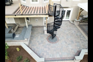 Inspiration for a mid-sized timeless backyard concrete paver patio remodel in Philadelphia with a fireplace and a pergola