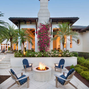 Immagine di un grande patio o portico tropicale dietro casa con un focolare, nessuna copertura e pavimentazioni in pietra naturale