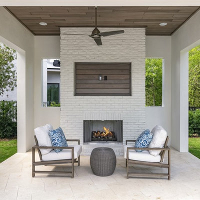 Inspiration for a mid-sized transitional backyard stone patio remodel in Orlando with a gazebo and a fireplace