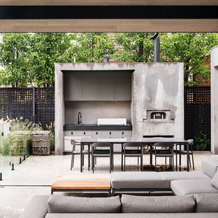 Foto di un patio o portico industriale di medie dimensioni e dietro casa con lastre di cemento e un parasole
