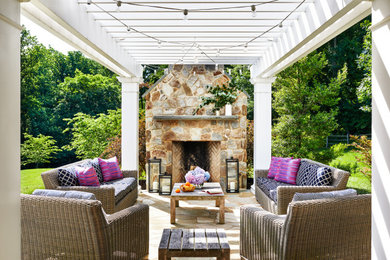 Patio - traditional stone patio idea in Baltimore with a fireplace and a pergola