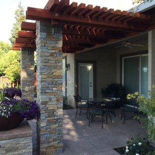 Immagine di un grande patio o portico chic dietro casa con cemento stampato e una pergola