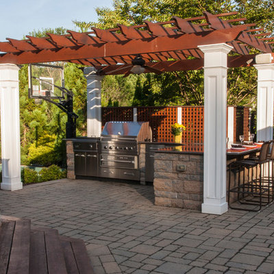 Inspiration for a mid-sized timeless backyard stone patio kitchen remodel in DC Metro with a pergola