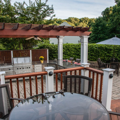 Inspiration for a mid-sized timeless backyard stone patio kitchen remodel in DC Metro with a pergola