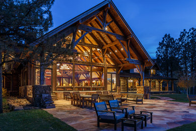 Mid-sized mountain style backyard stone patio photo in Denver with a roof extension