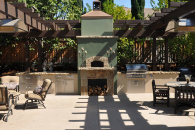 Example of an arts and crafts backyard stamped concrete patio kitchen design in San Francisco