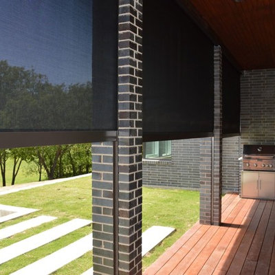 Example of a mid-sized classic backyard stone patio kitchen design in Dallas with a roof extension